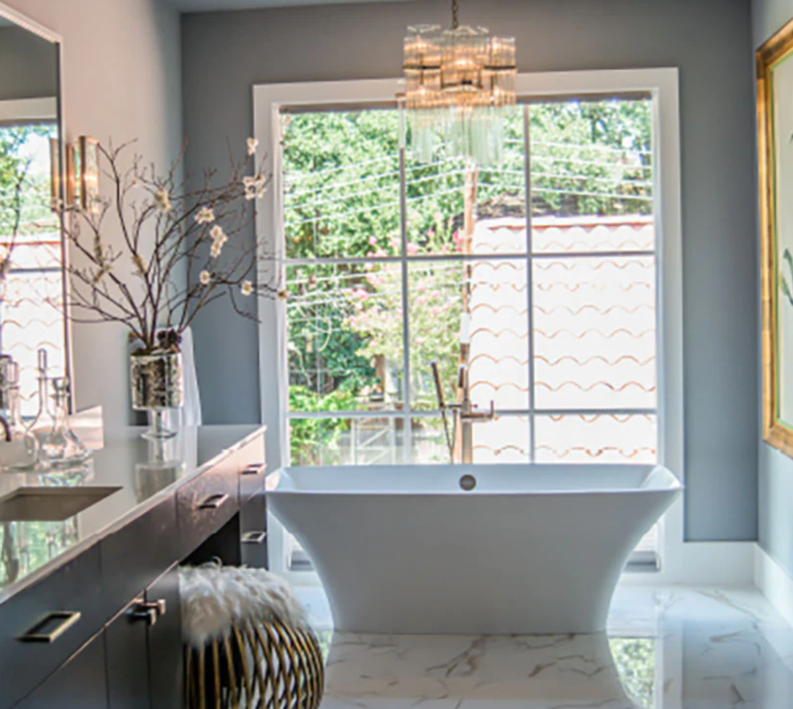 Modern bathroom with a freestanding bathtub, vanity, and large window.