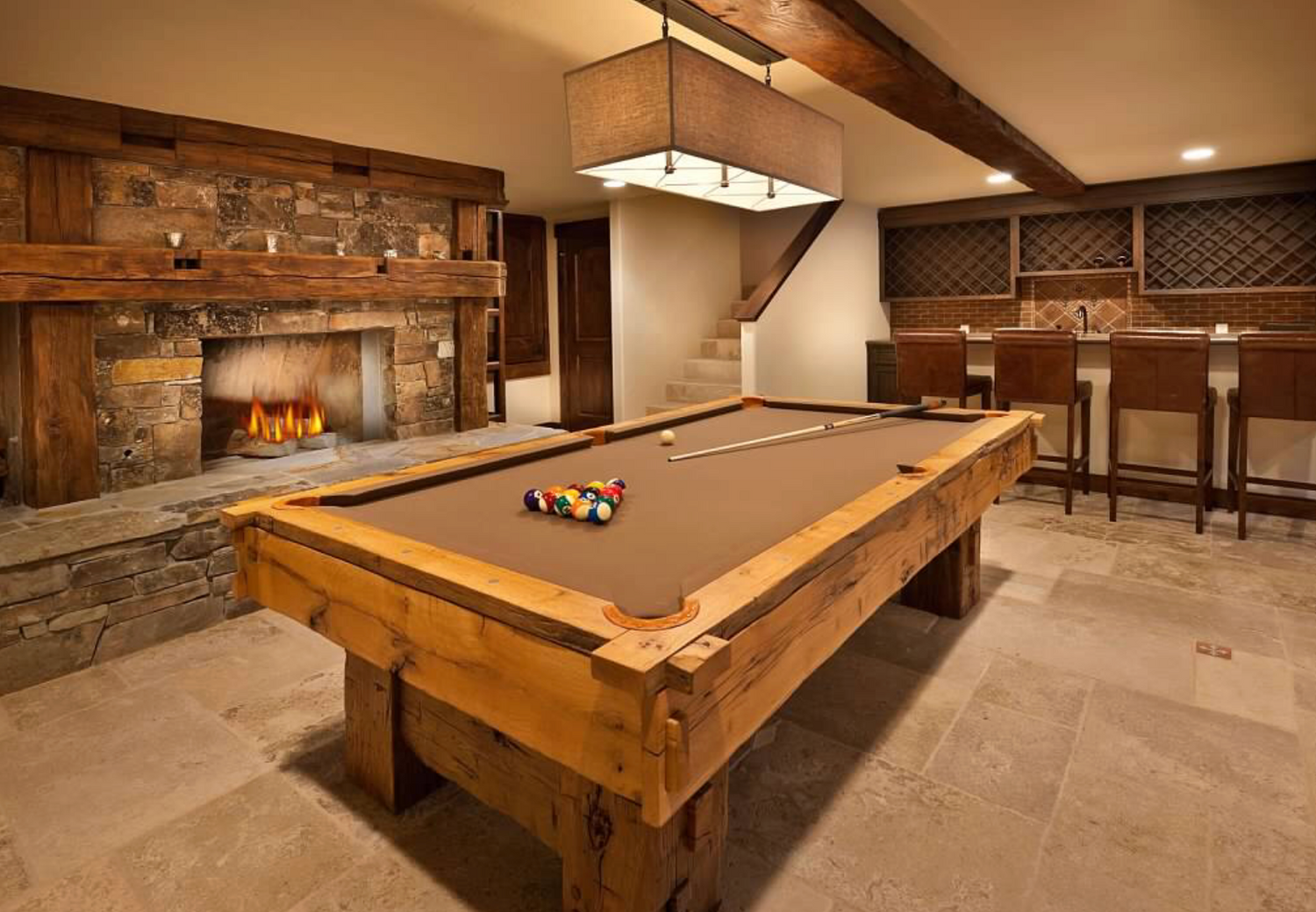 Game room with a pool table, fireplace, and bar area.