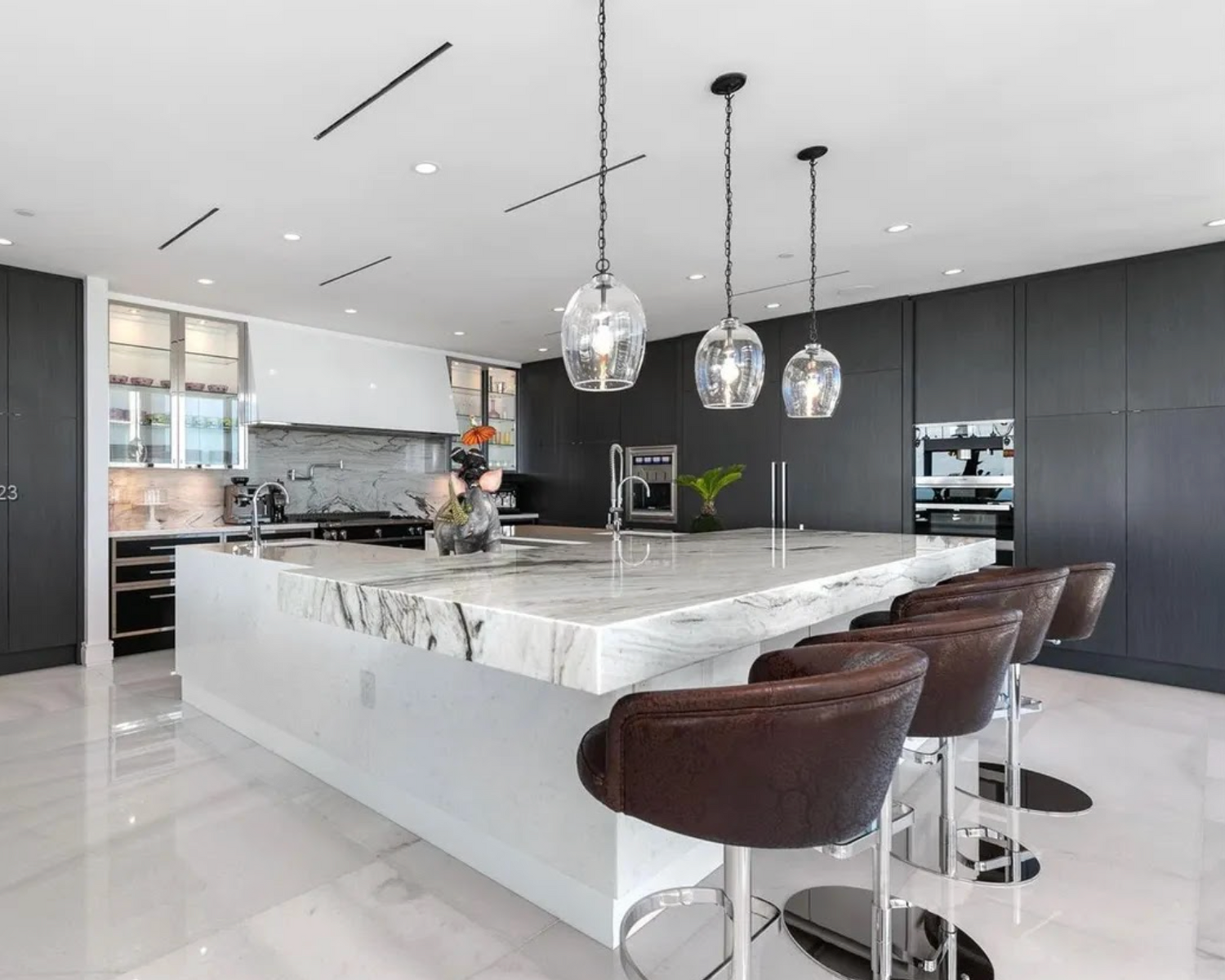 Modern kitchen with marble island and dark bar stools