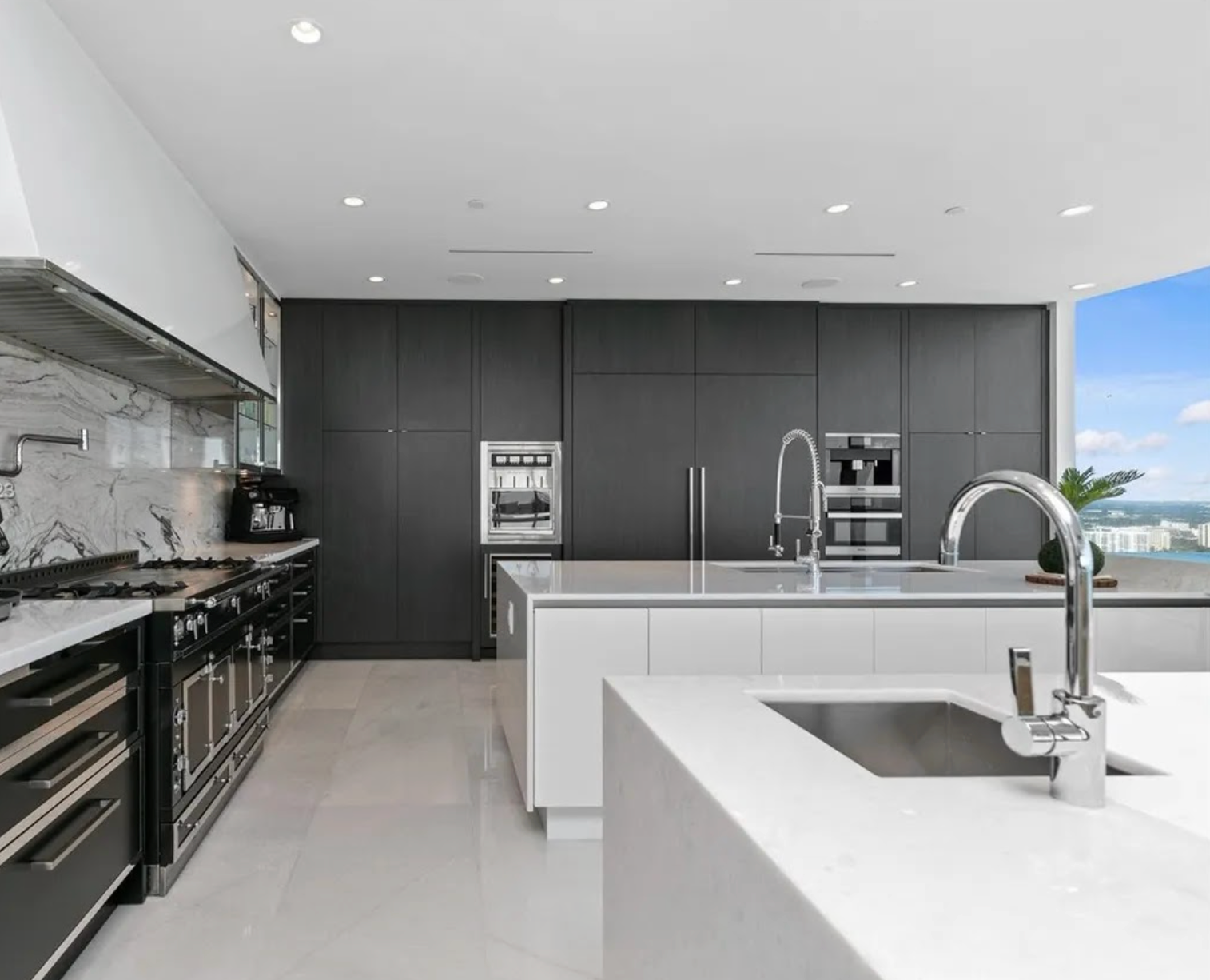 Modern kitchen with gray cabinets, white countertops, and stainless steel appliances.
