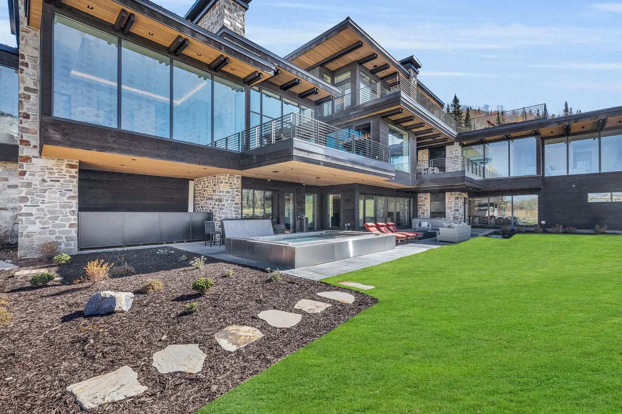 Modern house with large glass windows and a well-maintained garden