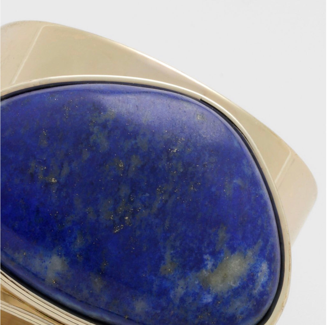 close up of a blue stone on a gold ring.