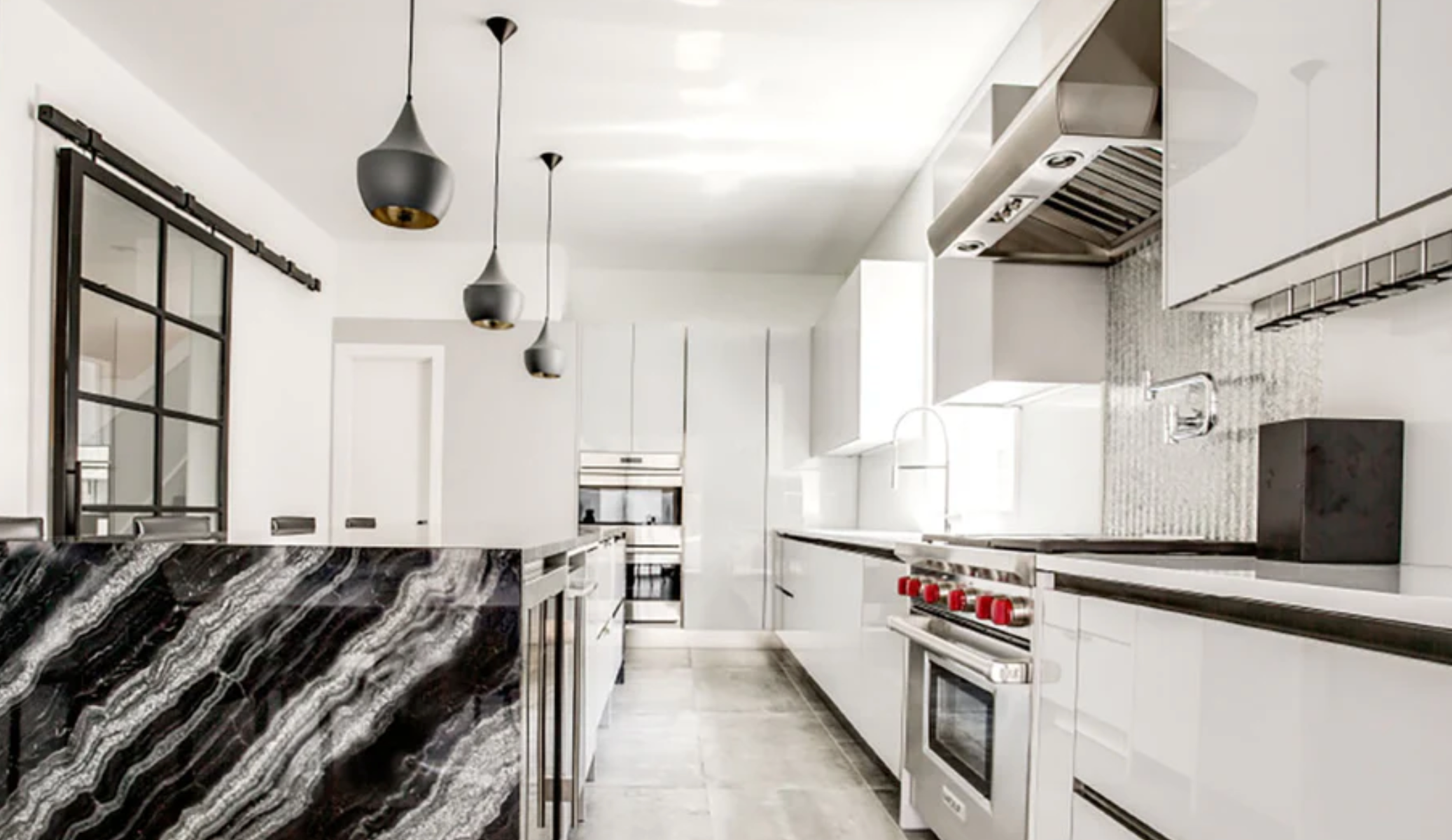 Kitchen with white glossy cabinets and black and white marble accents.