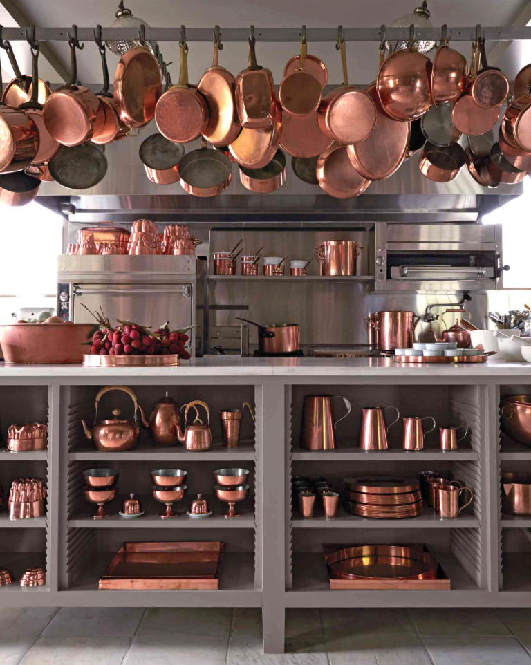 a kitchen shot full of copper pots hanging and in shelves