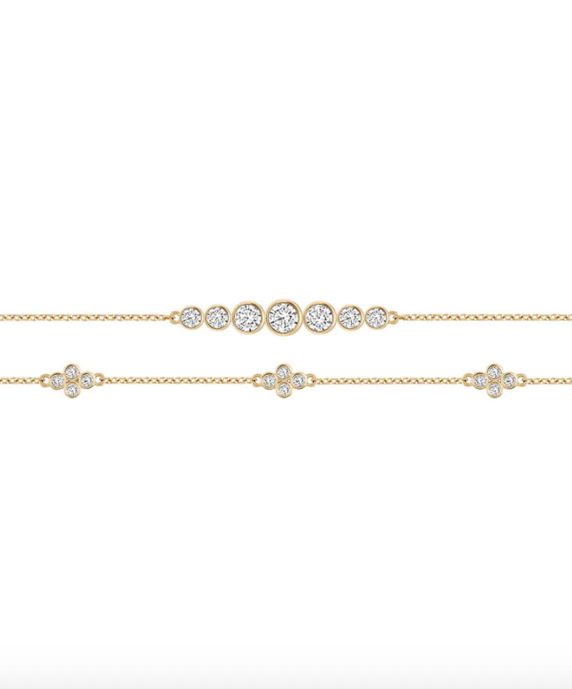 two thing gold bracelets with small circular diamonds float on a white background.