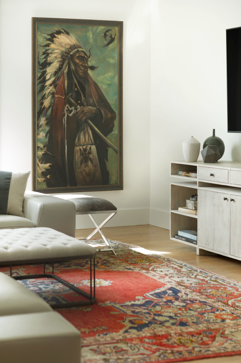 A image of a room with a large painting of a native american staring off in the distance.