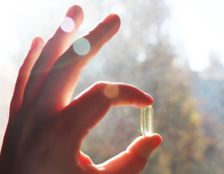 hand holds up to the sunlight a vitamin
