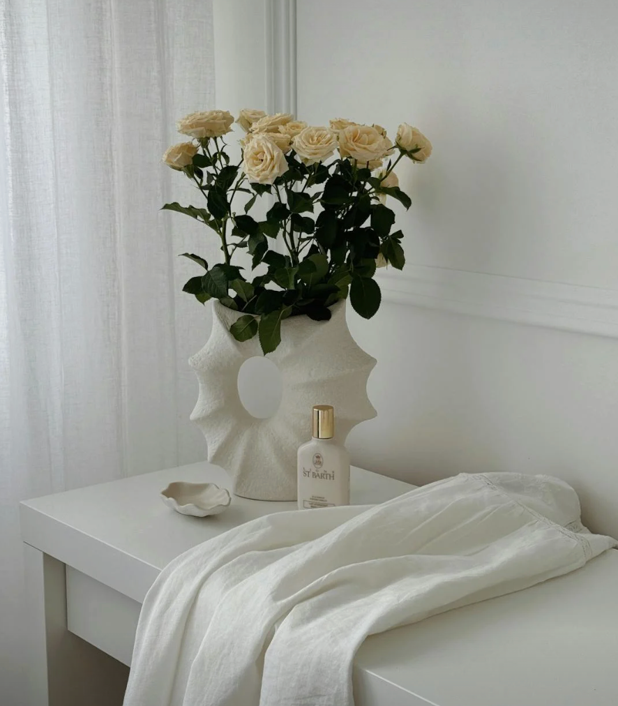 white roses in a architectural vase with all white decor
