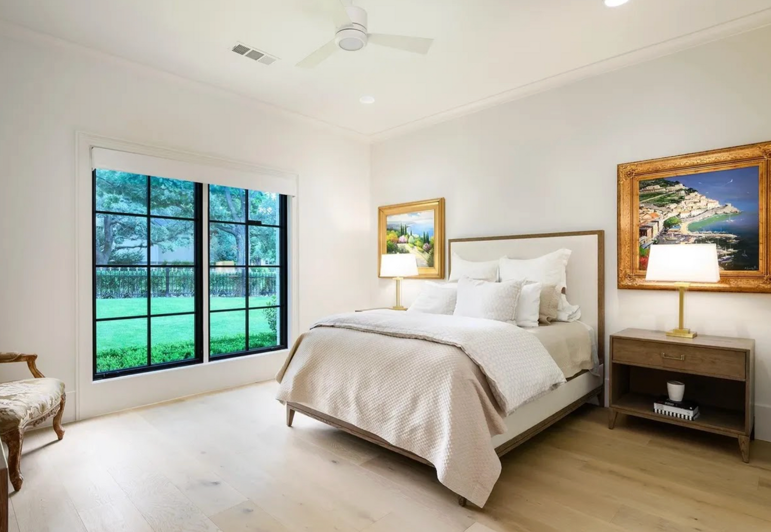 Modern bedroom with large windows, bed, and decorative items.