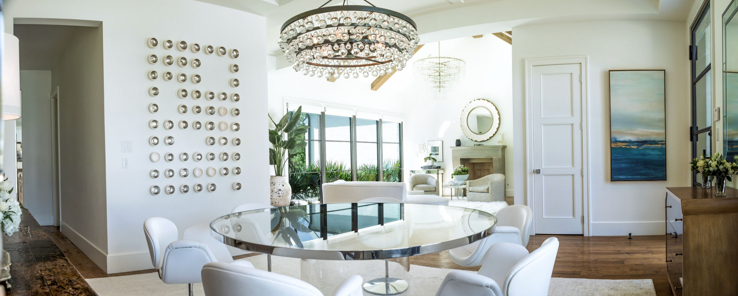 modern living room with large glass chandelier and circular glass top table.