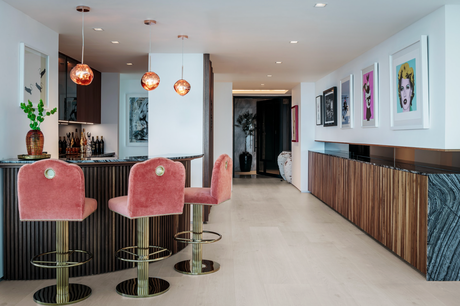 Modern kitchen with pink bar stools and decorative elements.