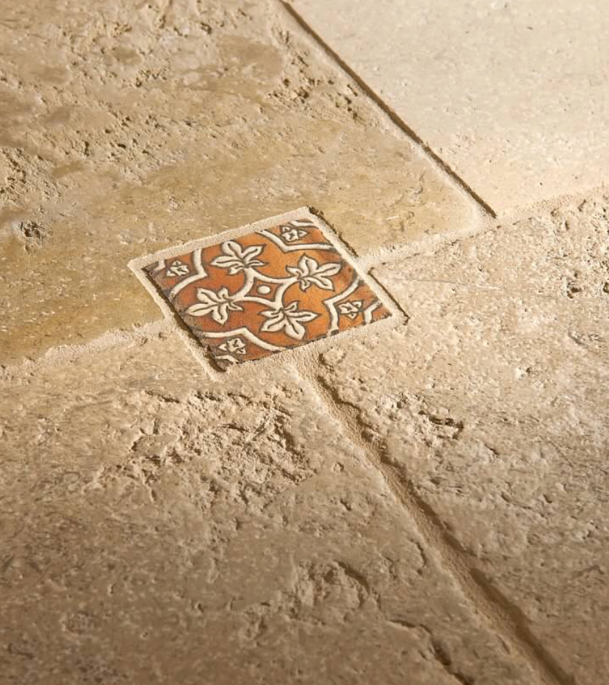 Decorative tile with floral pattern on a stone floor