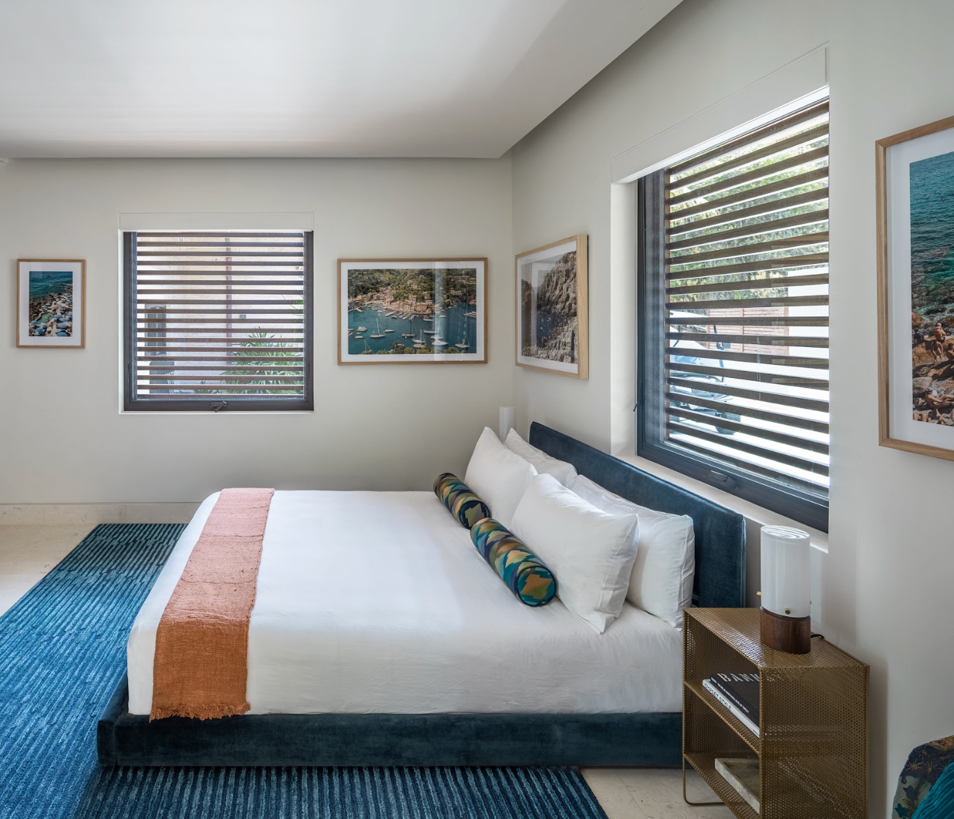 Shot of a bedroom with blue rug and white bed
