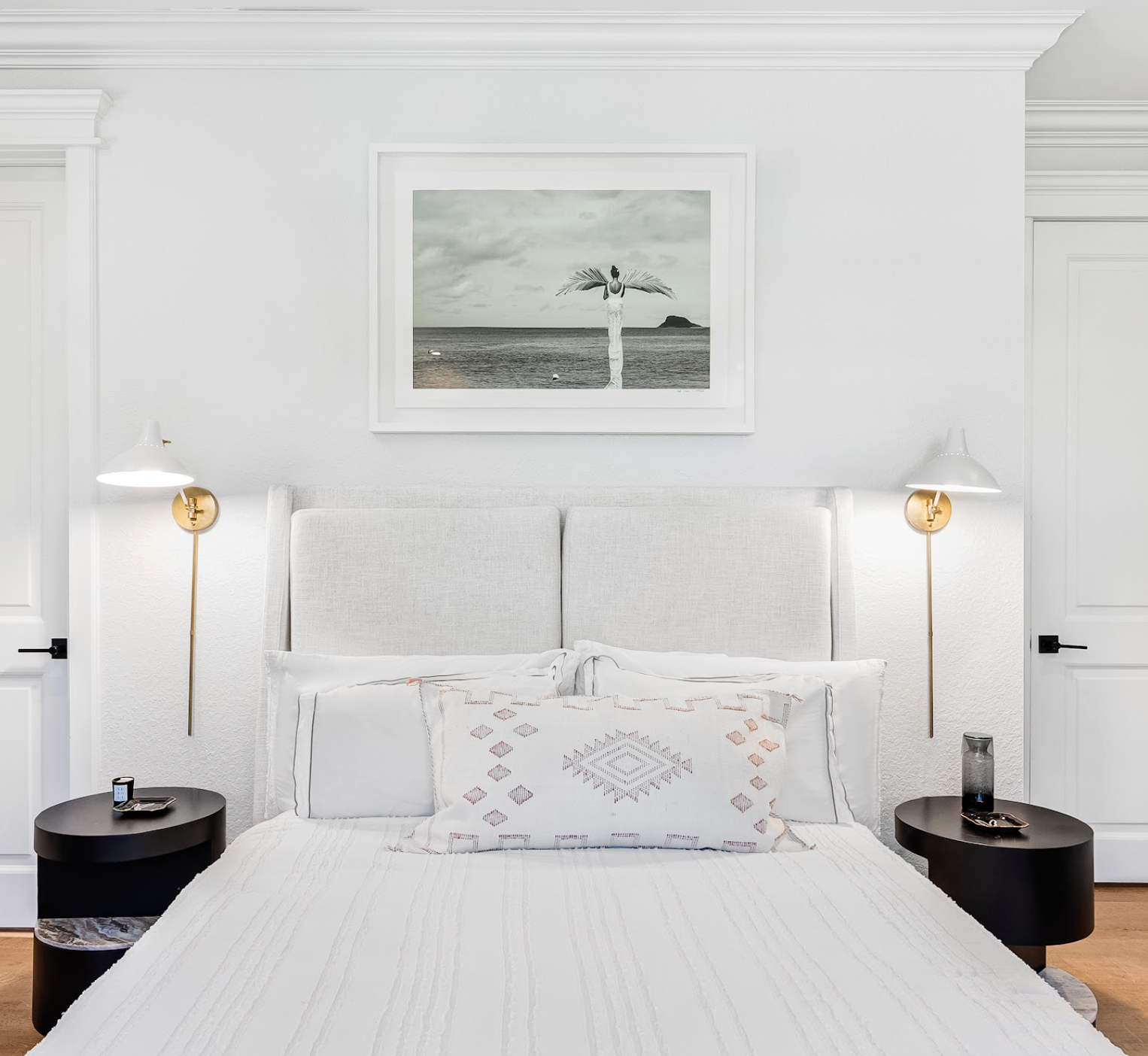 Modern bedroom with a bed, nightstands, and wall art.